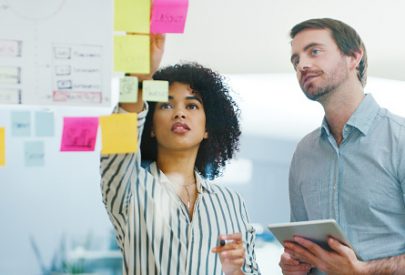 Shot of a young businessman and businesswoman using a digital tablet while having a brainstorming session in a modern office